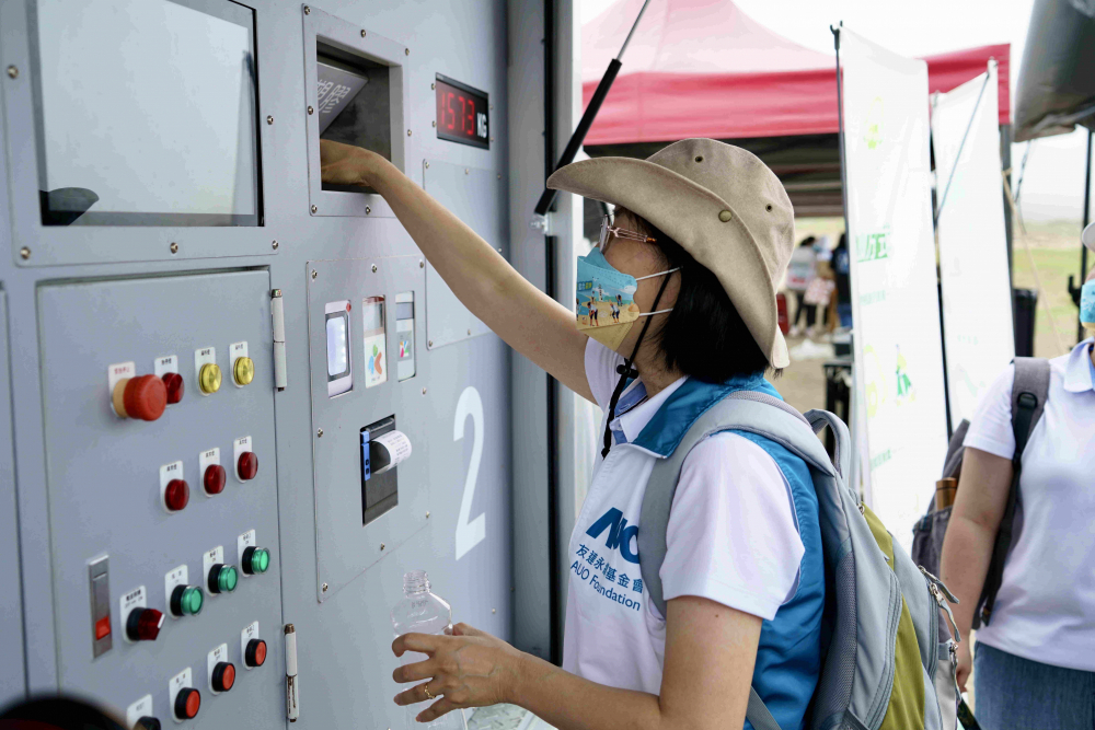 志工們將拾起的寶特瓶投入「好歸塑專車」，讓廢棄塑料空瓶可以直接粉碎、縮小體積，未來將可再製成購物袋、寶特衣、悠遊卡等生活用品